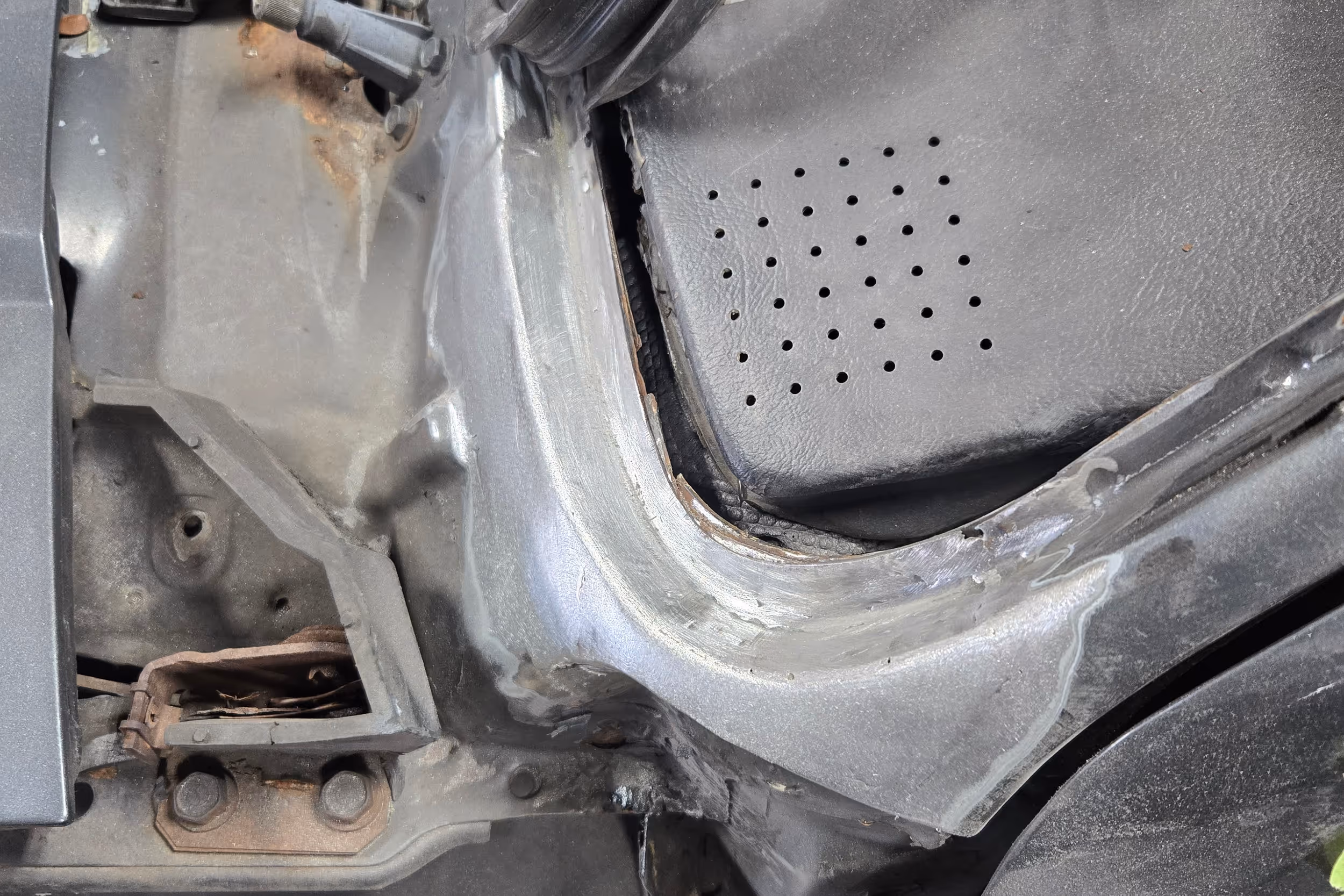 Before and after rust repair showing cut out rust and welded new metal section