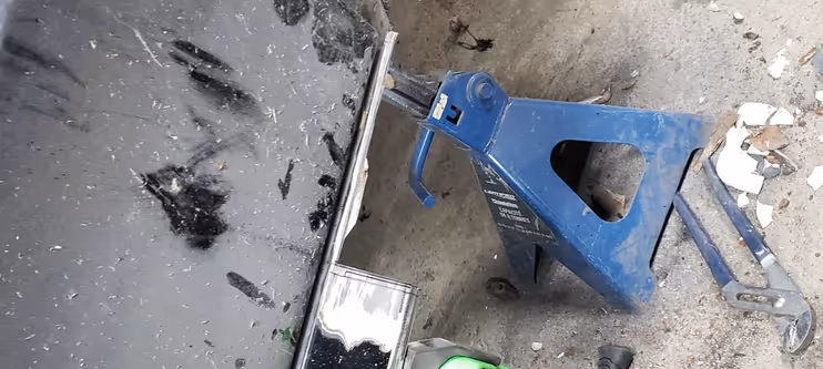 A close-up of severe rust and corrosion on a car cowl and windshield frame before restoration begins.