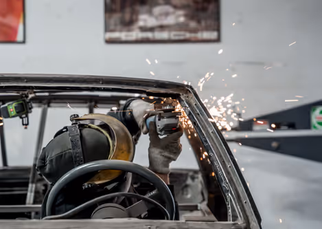 Grinding the front quarter frame with sparks during custom fabrication.