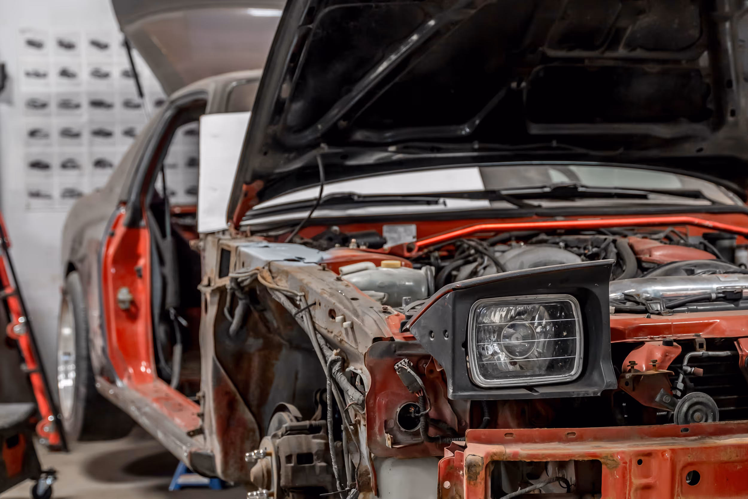 A red car quarter panel opened up for custom metal shaping and fabrication work.