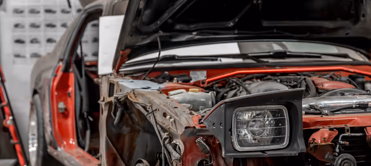A red car quarter panel disassembled for custom fabrication work.